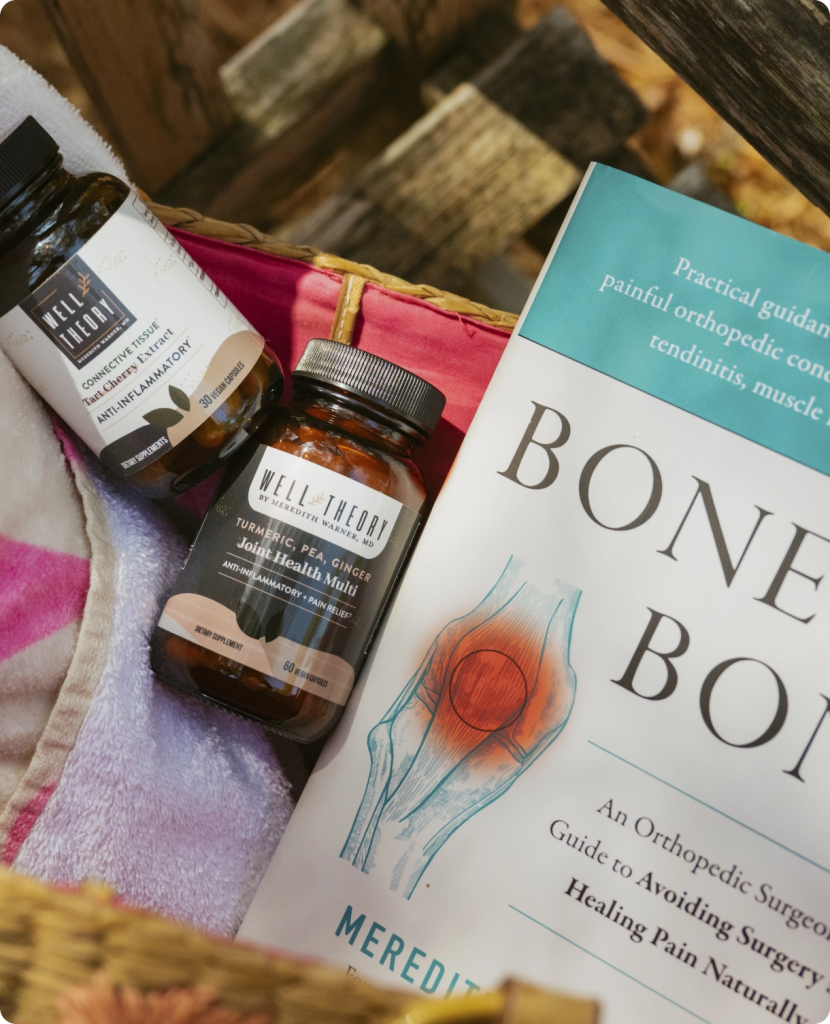 Supplements and a book titled "Bone on Bone" sit in a basket on a blanket, viewed from above.