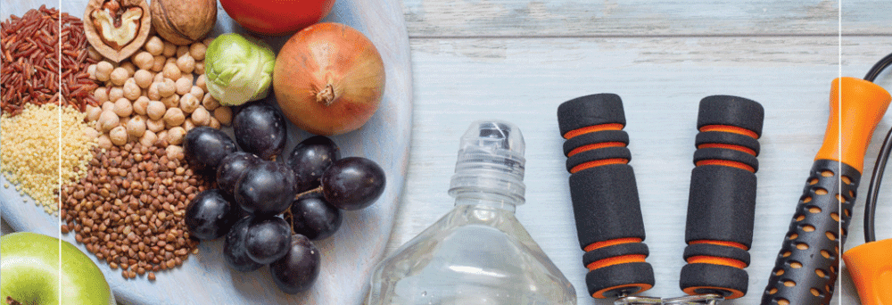 A plate of fruits, veggies, grains, water, hand grips, jump rope, and pain relief supplements on a wooden surface.