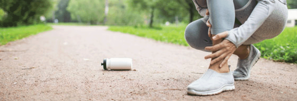 A person in athletic wear holds their painful ankle, possibly considering natural pain relief; a water bottle is nearby.