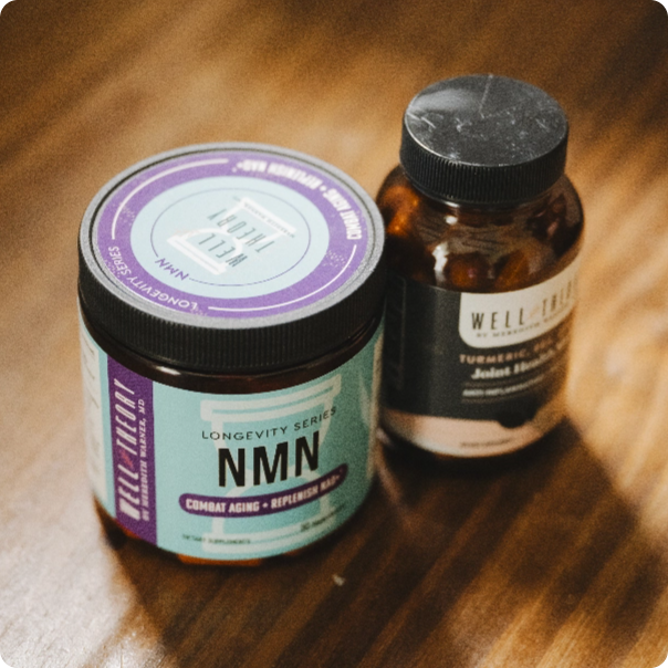 Two supplement bottles labeled "NMN" and "Well Theory" on a wooden surface, viewed from above.