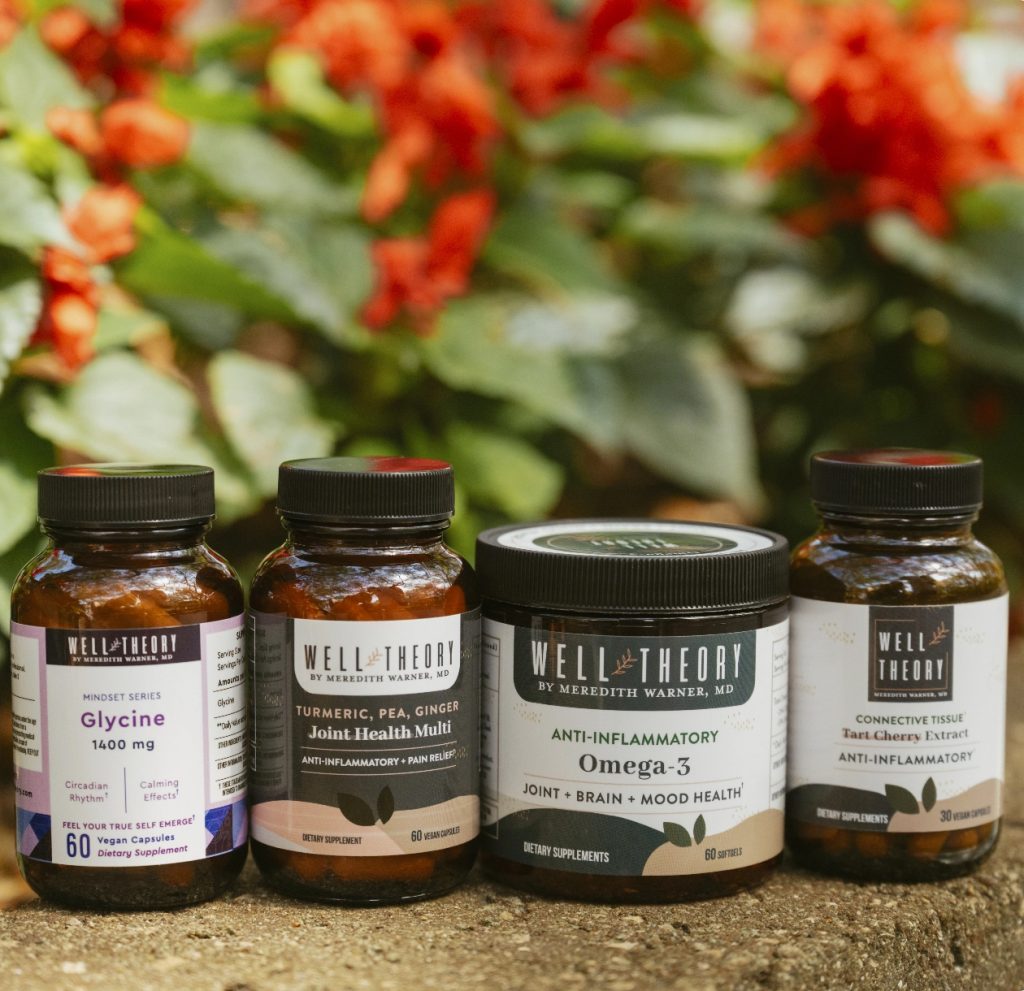 Four Well Theory supplements are displayed outdoors among green leaves and red flowers, suggesting natural pain relief.