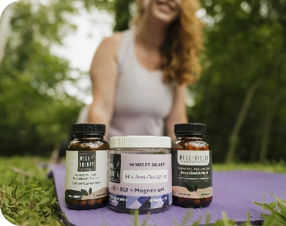 Three natural supplements sit on a yoga mat outside, with a peaceful person blurred in the background.